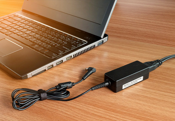 power adapter lying next to a laptop